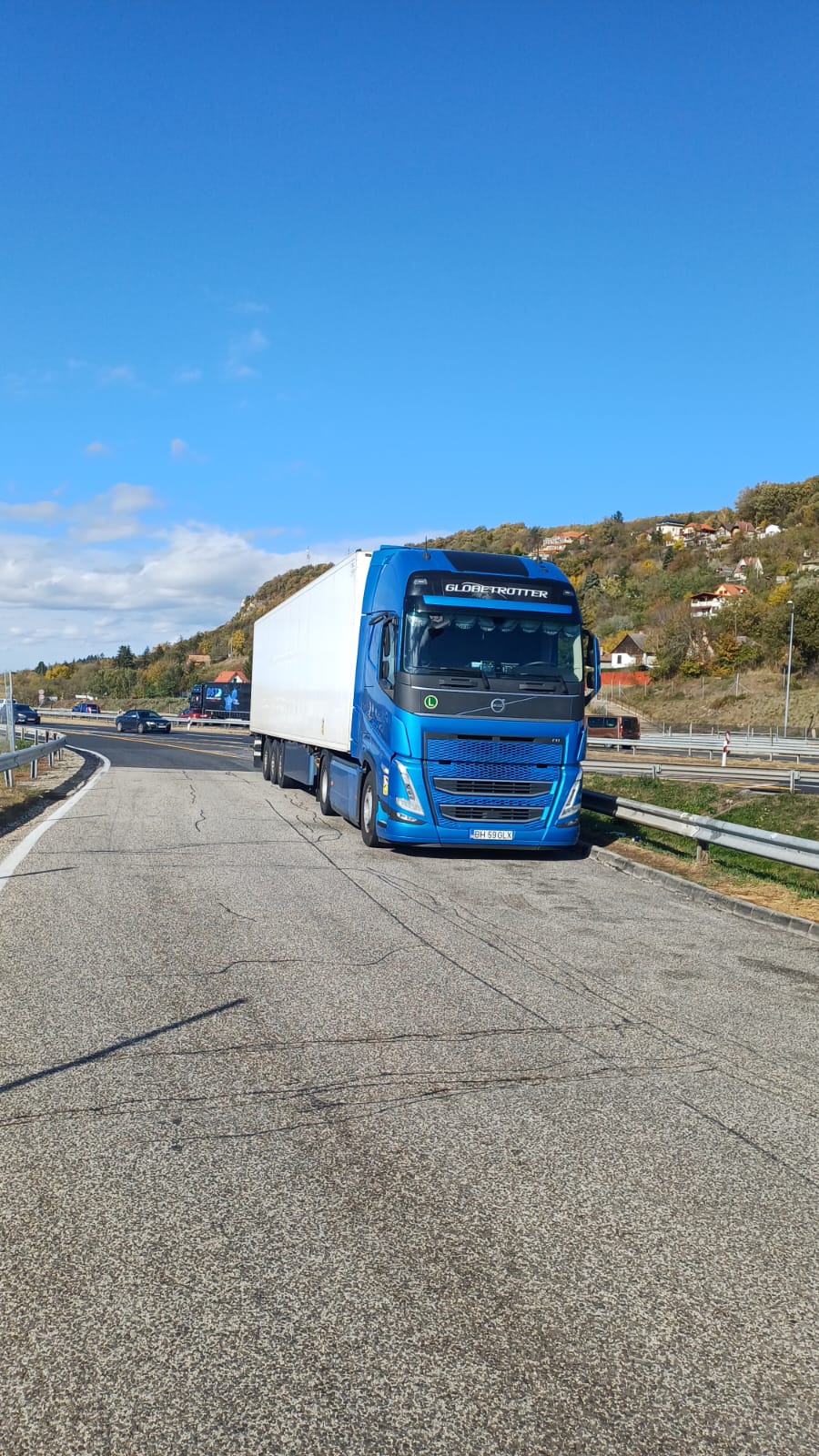 Camion Galexpres oprit pe marginea autostrăzii, cu relief de dealuri în fundal.